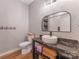 Modern half-bath featuring a dark granite countertop, white vessel sink, and open storage at 1816 Lisbon Ln, Charlotte, NC 28269