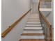 Bright staircase featuring wooden treads, white risers, and a wooden handrail with black metal spindles at 1816 Lisbon Ln, Charlotte, NC 28269