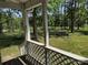 View from a covered back porch overlooking a lush, green yard and a fire pit at 1820 Trinity Church Rd, Monroe, NC 28112