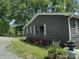 Exterior view of a single-story home featuring tasteful window shutters and landscaped flower beds at 1820 Trinity Church Rd, Monroe, NC 28112
