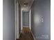 Hallway with hardwood floors and neutral paint provides seamless transition between spaces at 1820 Trinity Church Rd, Monroe, NC 28112