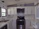 Bright kitchen featuring white cabinets, stainless steel appliances, and a modern countertop at 1820 Trinity Church Rd, Monroe, NC 28112