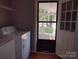 Well-lit laundry room with a washing machine, dryer, and access to the outdoors at 1820 Trinity Church Rd, Monroe, NC 28112