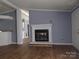 Open-concept living room with a decorative fireplace, neutral paint, and wood-look flooring at 1820 Trinity Church Rd, Monroe, NC 28112