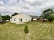 View of the home's backyard featuring a lush green lawn and a small concrete patio at 1876 Yellow Daisy Dr, Matthews, NC 28104