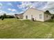 The home's backyard features a large, green lawn and a sliding glass door to the home's interior at 1876 Yellow Daisy Dr, Matthews, NC 28104