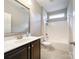 A well-lit bathroom features a shower-tub, dark vanity, and ample counter space at 1876 Yellow Daisy Dr, Matthews, NC 28104