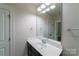 Bathroom with a dark vanity, white countertops, large mirror, and updated fixtures at 1909 Summey Ave, Charlotte, NC 28205