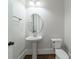 Powder room featuring a pedestal sink, hardwood floors, and updated fixtures at 1909 Summey Ave, Charlotte, NC 28205