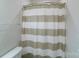Bathroom featuring white and tan striped shower curtain and chrome fixtures at 1909 Summey Ave, Charlotte, NC 28205