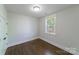 Cozy bedroom featuring warm hardwood floors, white walls, and a window providing natural light at 1909 Summey Ave, Charlotte, NC 28205