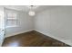 Bright bedroom with hardwood floors, a light fixture, and a window with blinds at 1909 Summey Ave, Charlotte, NC 28205