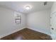 A well-lit bedroom with hardwood floors, a window, and white walls at 1909 Summey Ave, Charlotte, NC 28205