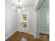 Bright foyer with hardwood floors, a modern light fixture, coat closet and a door with glass window to the outside at 1909 Summey Ave, Charlotte, NC 28205