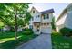 Charming two-story home featuring a well-manicured lawn, attached garage and covered entryway, creating curb appeal at 1909 Summey Ave, Charlotte, NC 28205