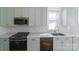 Close-up of a modern kitchen featuring stainless steel appliances, white cabinetry, and stylish hardware at 1909 Summey Ave, Charlotte, NC 28205