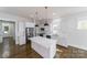 Modern kitchen featuring white cabinets, stainless steel appliances, large island, and hardwood flooring at 1909 Summey Ave, Charlotte, NC 28205
