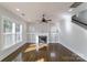 Spacious living room with a fireplace, built-in shelving, large windows, and hardwood floors at 1909 Summey Ave, Charlotte, NC 28205