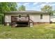 View of the home's backyard with a wooden deck and lush green lawn at 195 Kings Ter, Salisbury, NC 28146