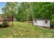 Expansive backyard featuring green grass, trees, and a shed for storage at 195 Kings Ter, Salisbury, NC 28146