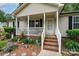 Close-up of the front porch with brick steps and white railings, surrounded by colorful flower beds at 195 Kings Ter, Salisbury, NC 28146