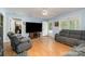 Comfortable living room featuring wood flooring, a large television, and access to the front porch at 195 Kings Ter, Salisbury, NC 28146