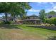 Beautiful backyard with lush lawn, stone retaining wall, professional landscaping, and mature trees at 19501 River Falls Dr, Davidson, NC 28036