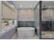 Modern bathroom featuring a freestanding tub, tiled walls, and a glass-enclosed shower at 19501 River Falls Dr, Davidson, NC 28036