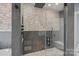 Modern bathroom with glass shower, decorative tile, and marble flooring, offering luxury and style at 19501 River Falls Dr, Davidson, NC 28036