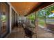 Charming covered porch with stone columns, wood ceiling, and serene golf course views at 19501 River Falls Dr, Davidson, NC 28036