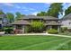 Stunning exterior of stone home with manicured lawn and lush landscaping at 19501 River Falls Dr, Davidson, NC 28036