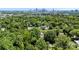 Overhead view shows a home surrounded by dense trees with the city skyline visible in the distance at 2008 Highland St, Charlotte, NC 28208