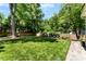 Spacious backyard featuring a lush lawn, privacy fence, and a stone fire pit seating area at 2008 Highland St, Charlotte, NC 28208