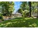 Beautifully landscaped backyard featuring a lush lawn, mature trees, and a cozy fire pit area at 2008 Highland St, Charlotte, NC 28208