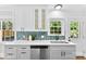 Well-lit kitchen with white cabinets, quartz countertops, and a view of the backyard at 2008 Highland St, Charlotte, NC 28208