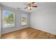 Bright, empty bedroom features hardwood floors and two windows for natural light at 2025 Groves Edge Ln, Waxhaw, NC 28173