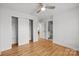 Bright bedroom features wood flooring, a ceiling fan, and sliding door closet at 2025 Groves Edge Ln, Waxhaw, NC 28173