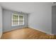 Empty bedroom features hardwood floors and a large window for natural light at 2025 Groves Edge Ln, Waxhaw, NC 28173