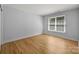 Empty bedroom features hardwood floors and a large window for natural light at 2025 Groves Edge Ln, Waxhaw, NC 28173
