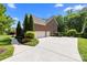 Brick home exterior with a three car garage and beautifully landscaped front yard at 2025 Groves Edge Ln, Waxhaw, NC 28173