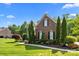 Traditional brick home boasts manicured landscaping, mature trees, and a well-maintained lawn at 2025 Groves Edge Ln, Waxhaw, NC 28173