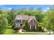 Beautiful two-story brick home with manicured lawn and mature landscaping at 2025 Groves Edge Ln, Waxhaw, NC 28173