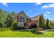 Well-maintained brick home with a manicured lawn and mature trees at 2025 Groves Edge Ln, Waxhaw, NC 28173