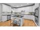 Well-lit modern kitchen features white cabinetry, granite countertops, a kitchen island and stainless steel appliances at 2025 Groves Edge Ln, Waxhaw, NC 28173