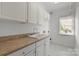 Bright and functional laundry room with ample counter space, storage cabinets, and a utility sink at 2025 Groves Edge Ln, Waxhaw, NC 28173