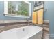 Bathroom featuring a soaking tub and tiled walls at 219 Reese Wilson Rd, Belmont, NC 28012