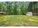 Green backyard features a shed, mature trees, and a well-manicured lawn for outdoor activities at 2379 Whitley Rd, Fort Mill, SC 29708