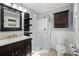 Well-lit bathroom featuring a glass-enclosed shower, dark vanity, and storage cabinet at 2379 Whitley Rd, Fort Mill, SC 29708