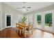 Bright dining area with hardwood flooring, ceiling fan, natural light, and access to the backyard through double doors at 2379 Whitley Rd, Fort Mill, SC 29708