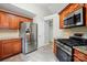 Kitchen with stainless steel refrigerator, stove, tile backsplash and wooden cabinets offering a functional design at 2379 Whitley Rd, Fort Mill, SC 29708